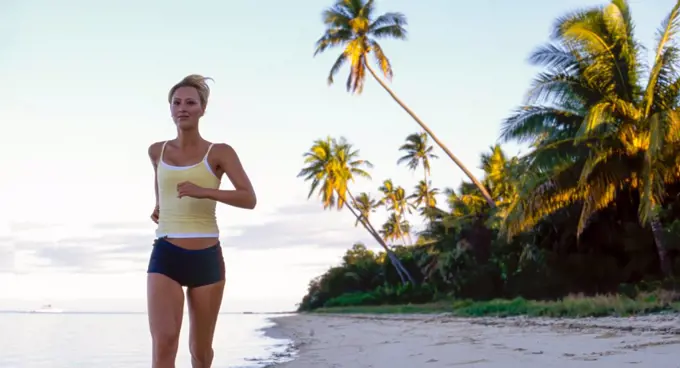 Young woman running on tropical beach