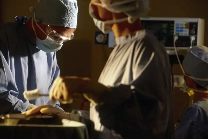 Nurses assisting doctor in theatre of hospital with operation