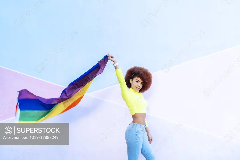 woman with afro hair displaying the lgtbi flag