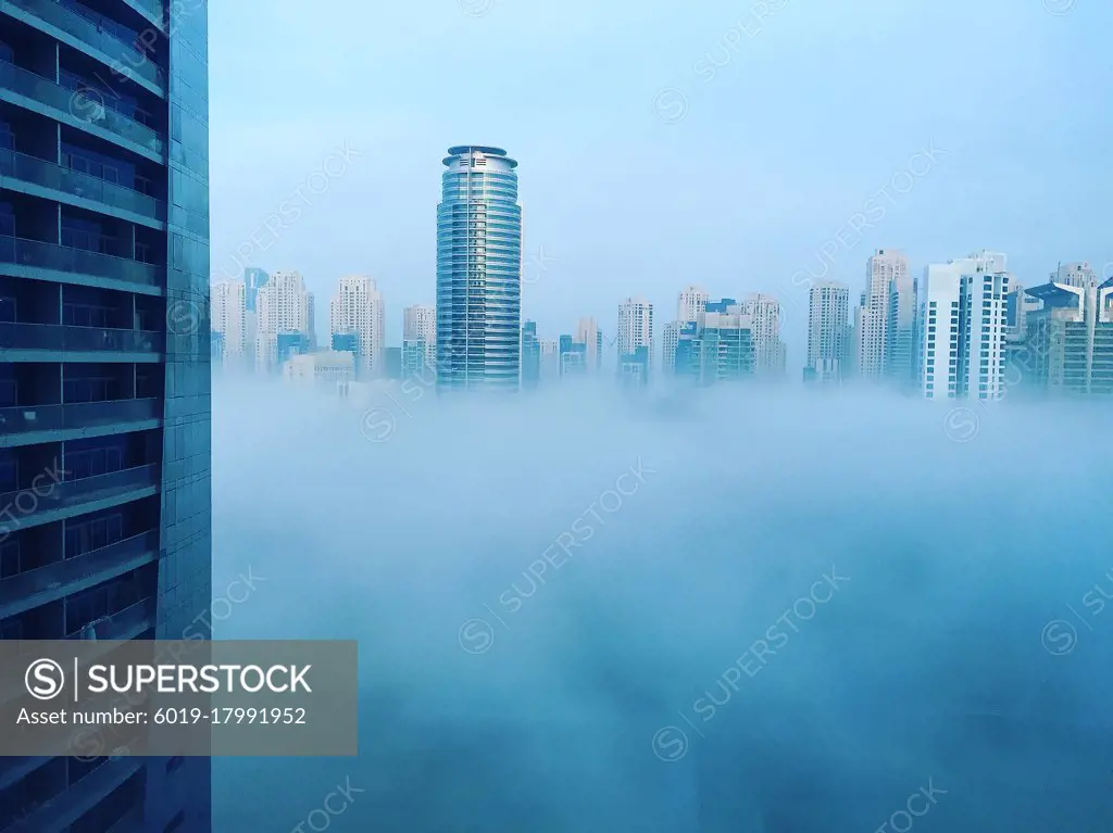 Modern skyscrapers of Dubai Marina in blue fog, climate change