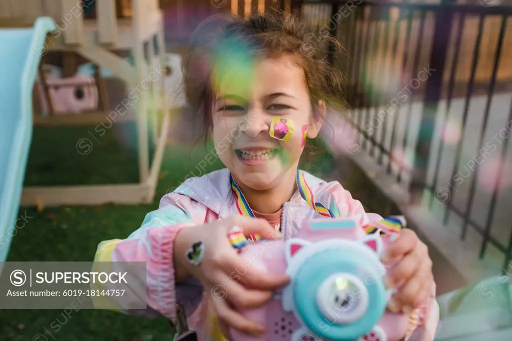 Smiling girl playing with bubbles in back yard