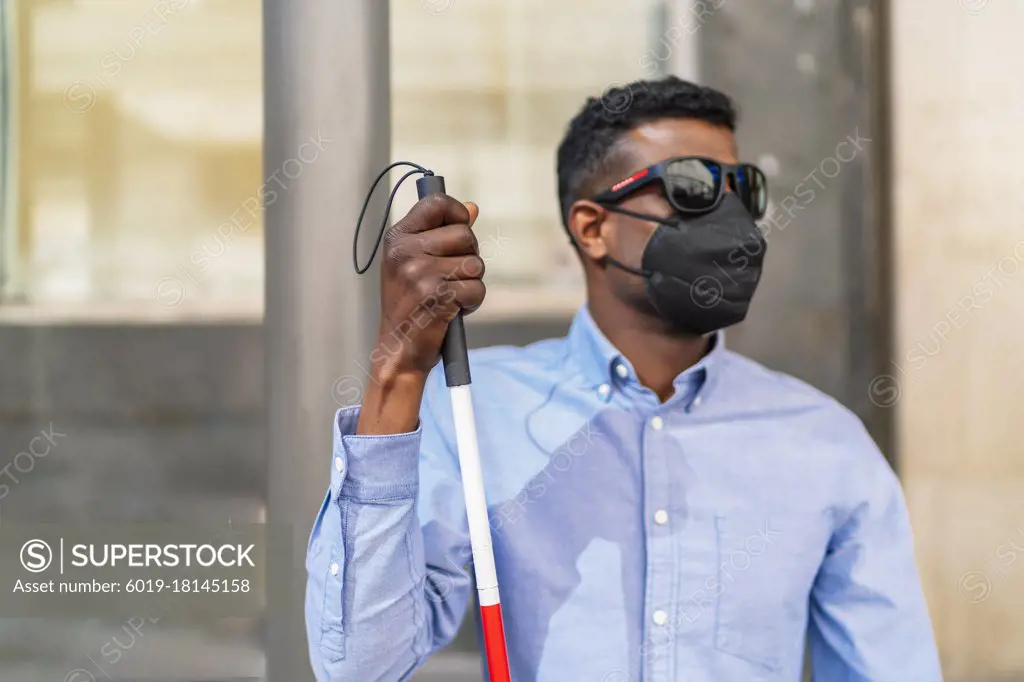 young blind african man waiting for the bus