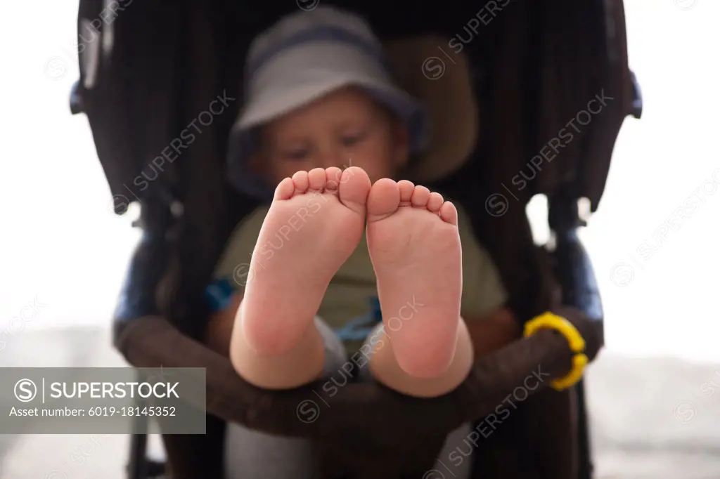 Baby feet sitting in a stroller closeup