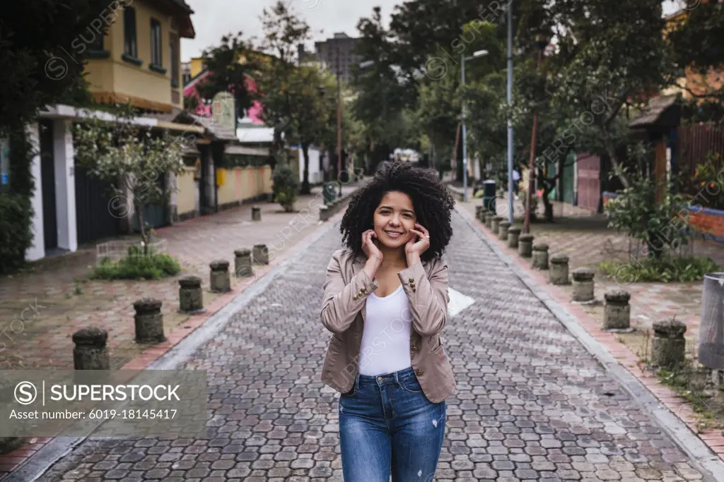 Portrait of cute girl with curly hair on the street