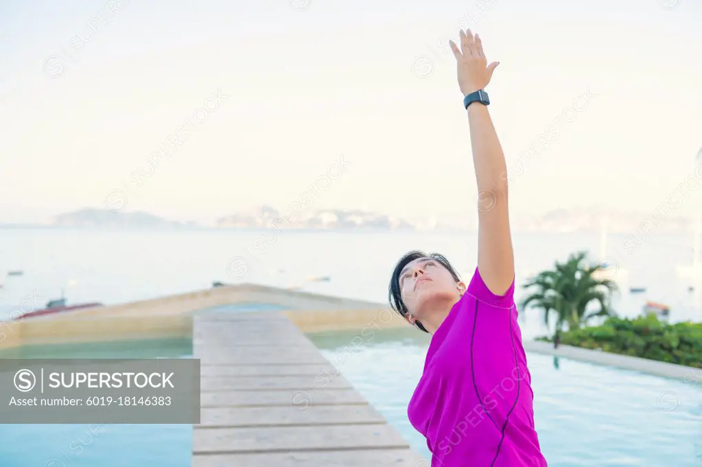 Woman practices yoga in front of the pool. Yoga poses outdoors