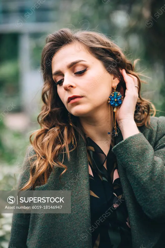 girl in a green coat with beautiful earrings