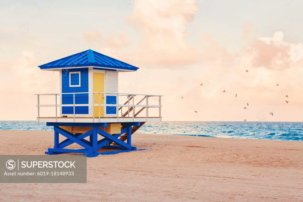 Empty Florida beach with lifeguard house on sunset. Ocean landscape.