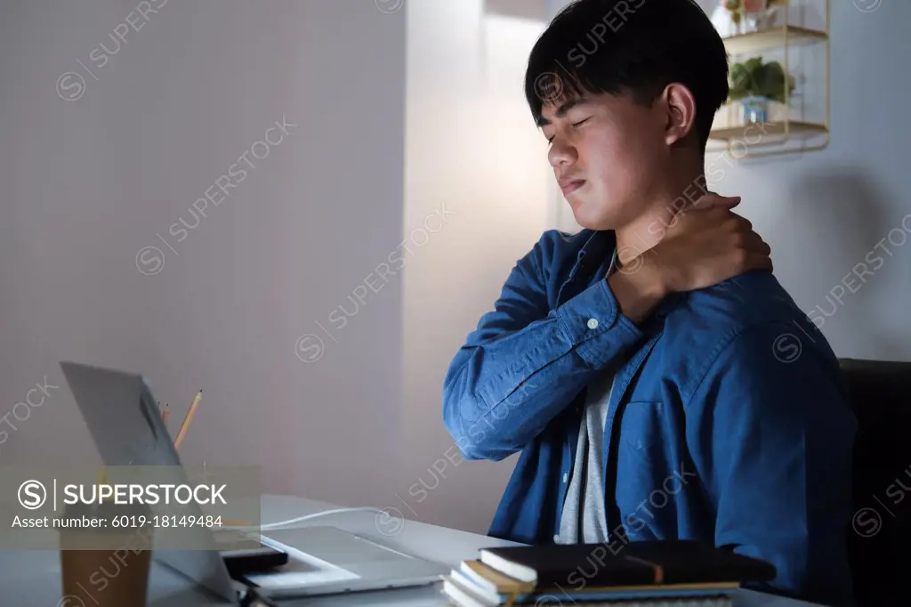 Young man overtime work and feel shoulder and neck pain at home