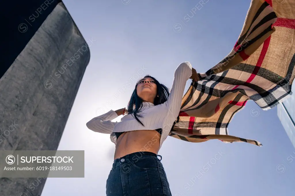 Young Latin woman moving and playing with a ruana.