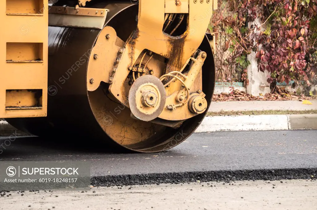 Laying of asphalt. Road roller tamping asphalt