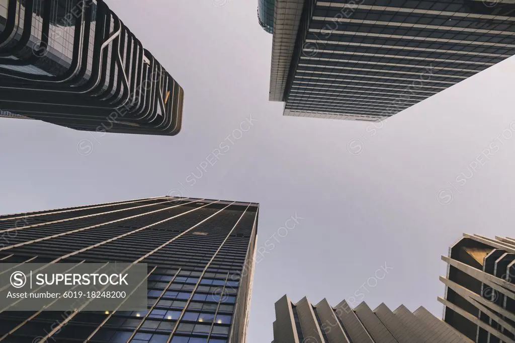 Low view of financial district skyscrapers at sunrise in Singapore city center.