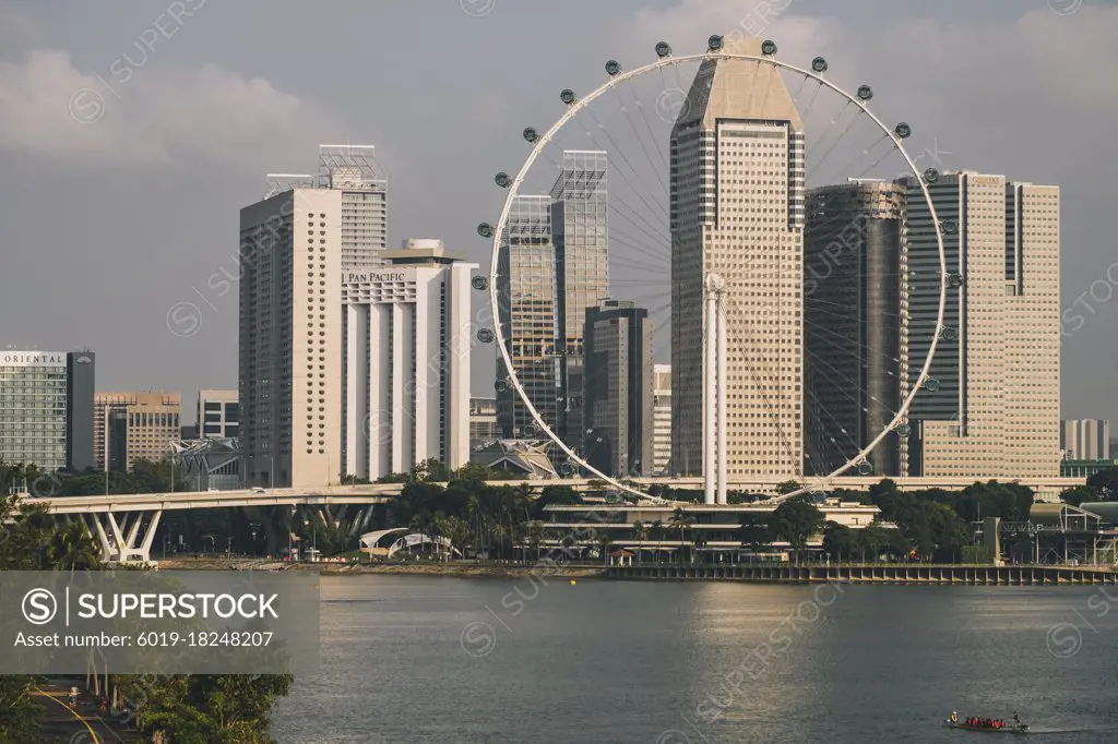 Singapore Flyer, 165m tall public observation wheel against cloudy sky during sunrise in Singapore.