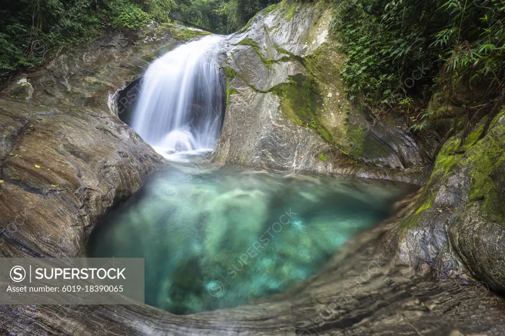 Beautiful green rainforest waterfall with crystal clear water pool