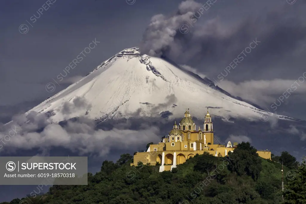 Morning view of church and a volcano behind with snow