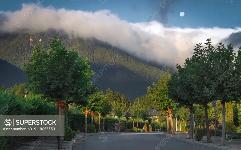 Morning road to the mountains in the clouds with moon