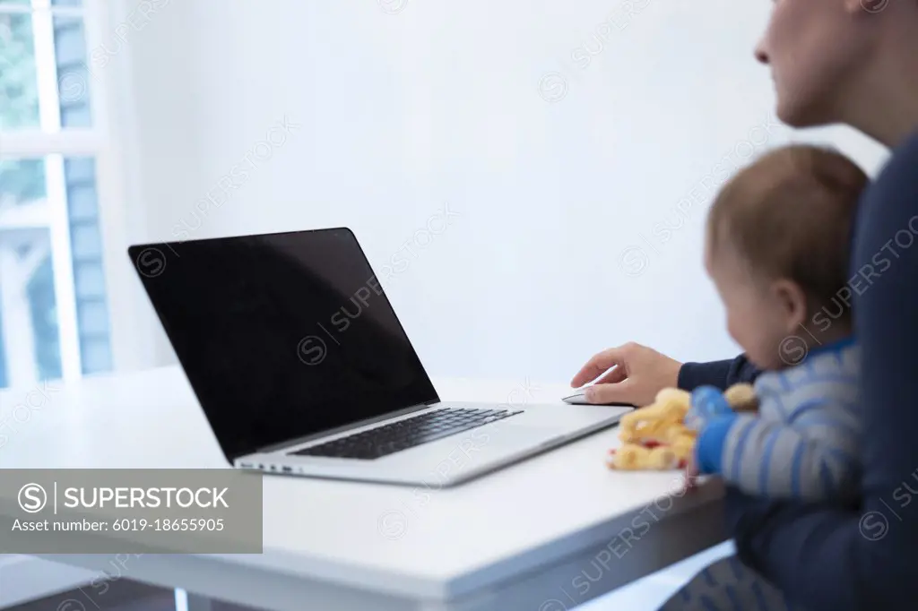 Working mother with holding the baby on lap