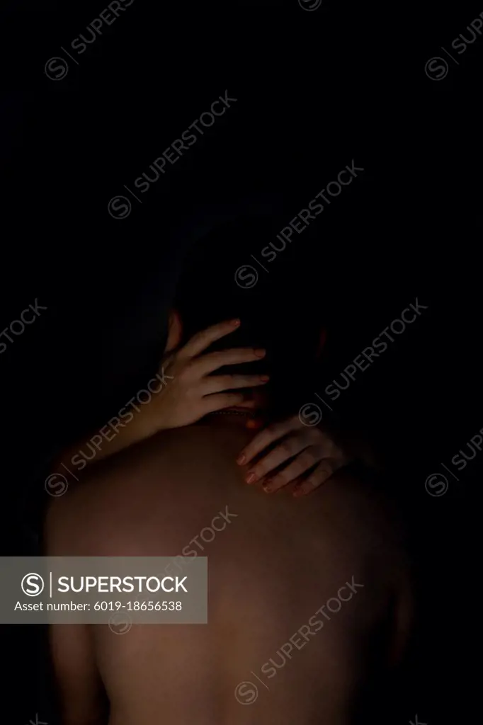 Close-up of romantic naked couple at studio shot on black background