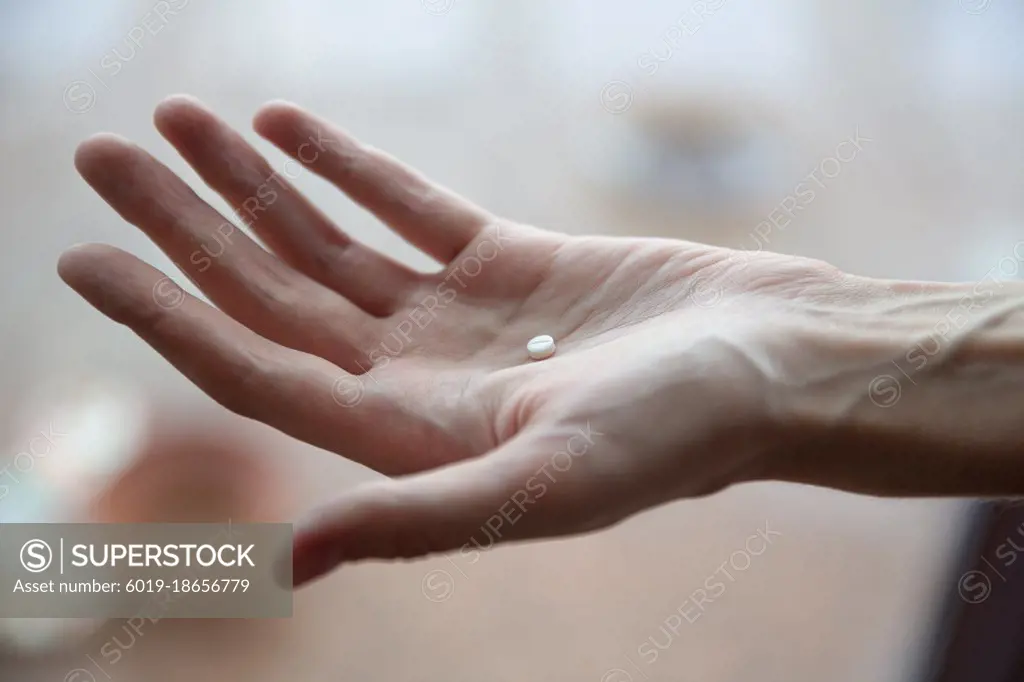 Image of woman with pills in hand