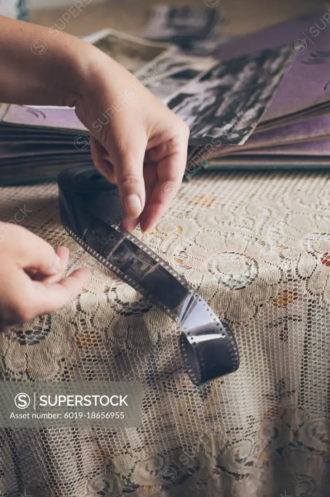 Woman looking at retro photos in vintage album, old photo film