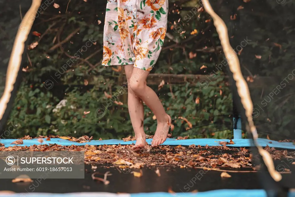 Jumping in the fall leaves on her trampoline