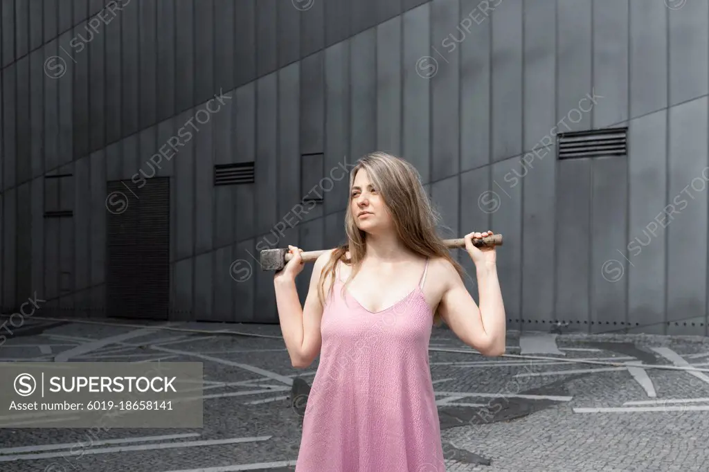 Young women holding a maul on her shoulders