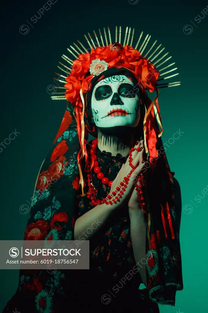 Young woman in calavera style with Mexican skull make-up on her face