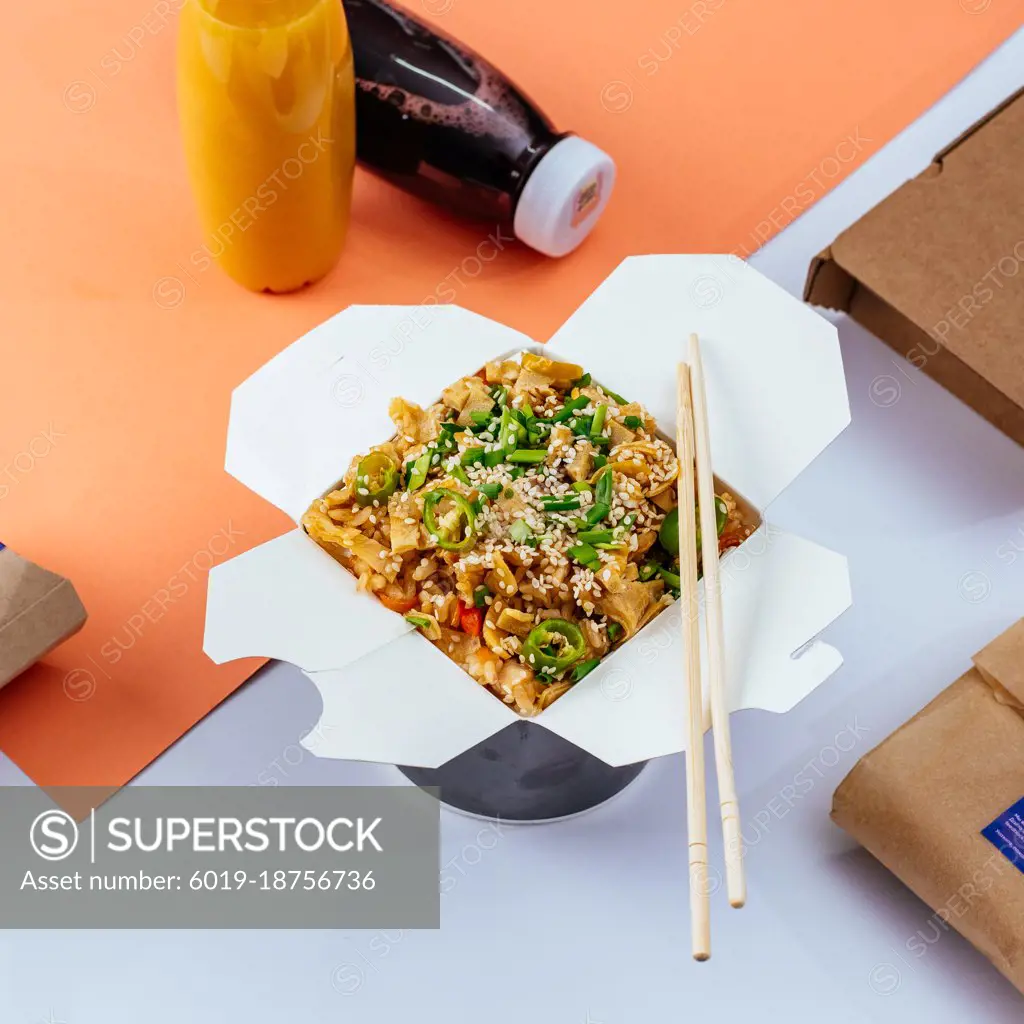 chinese rice noodles with chicken and vegetables in a takeaway box