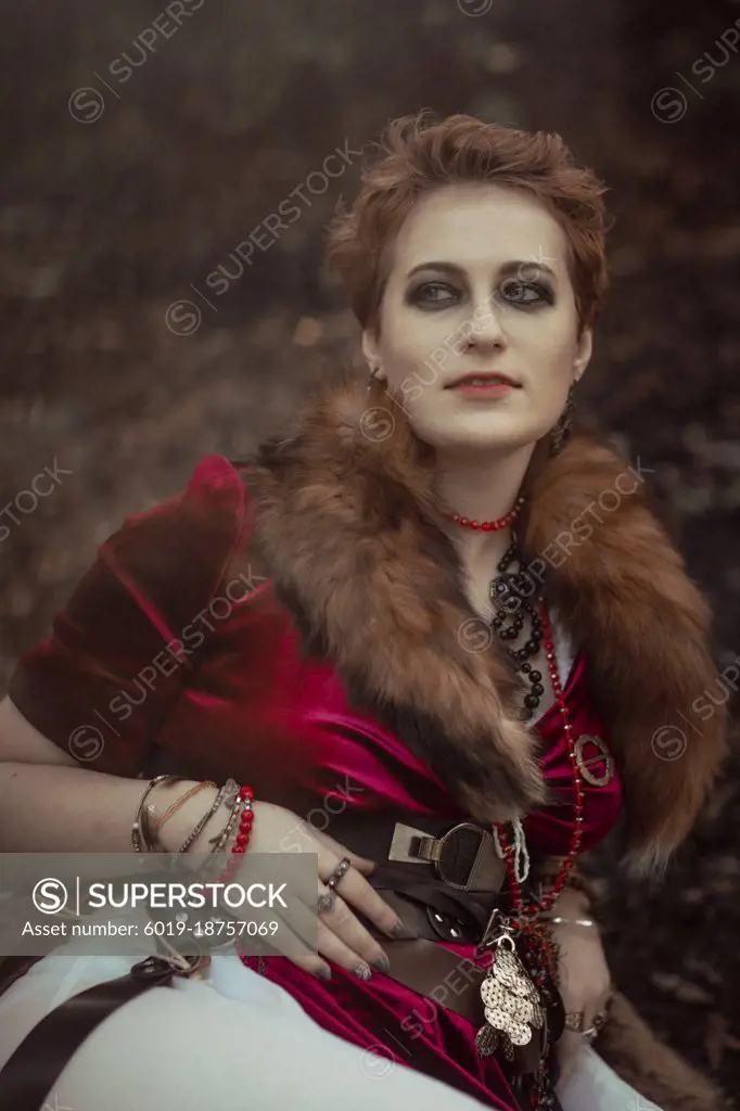 Witch with short hair in dress against the background of wild nature ...