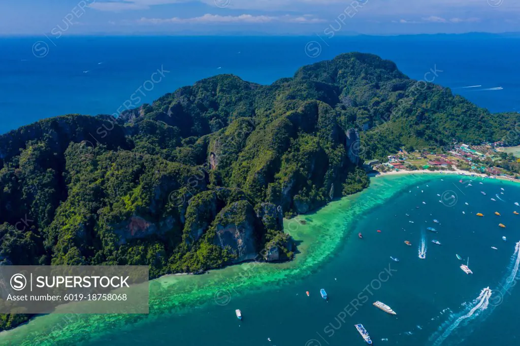 Blue clear water with boats. Green tropical island Phi Phi, palm