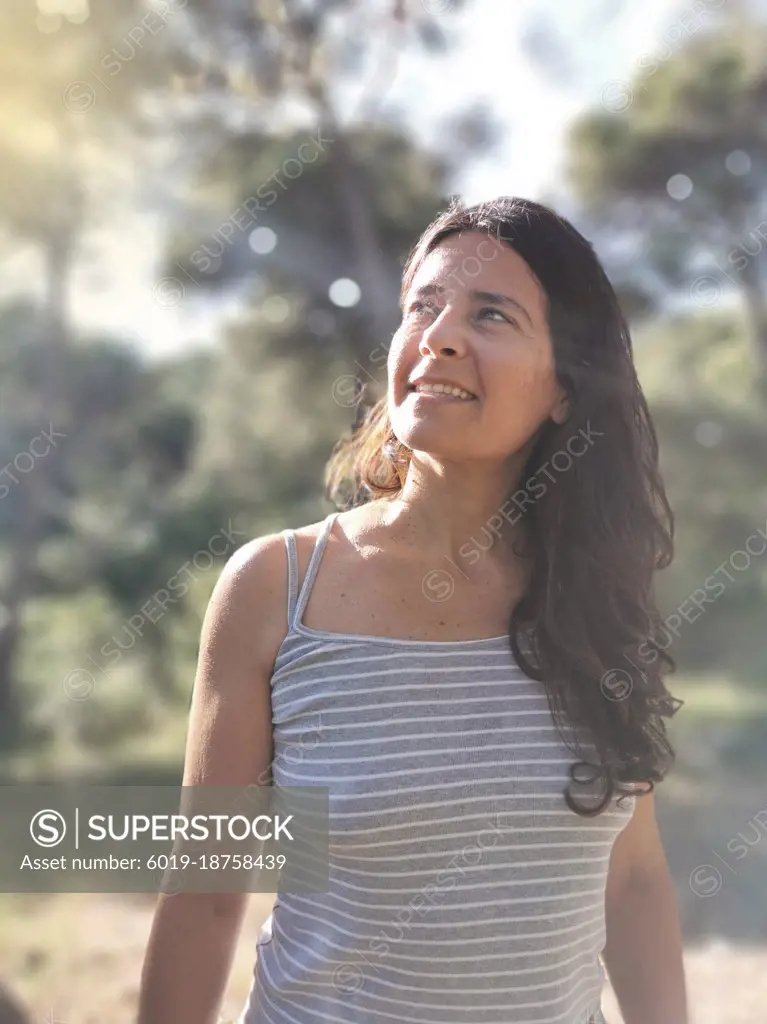 Happy  spanish  middle-aged woman posing in the forest