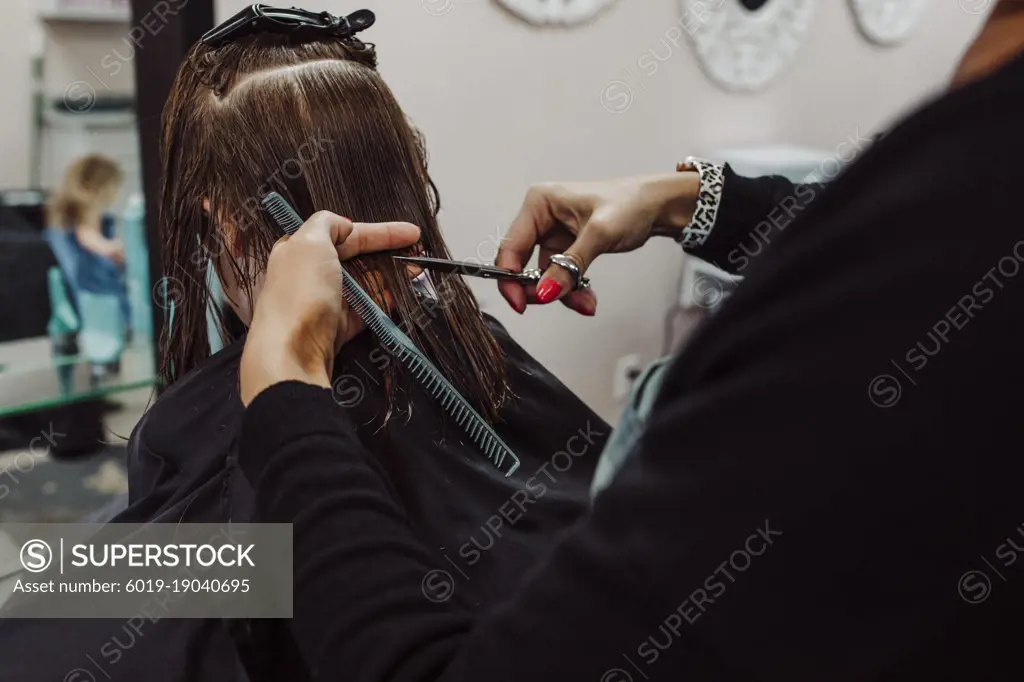 Little girl getting haircut by woman