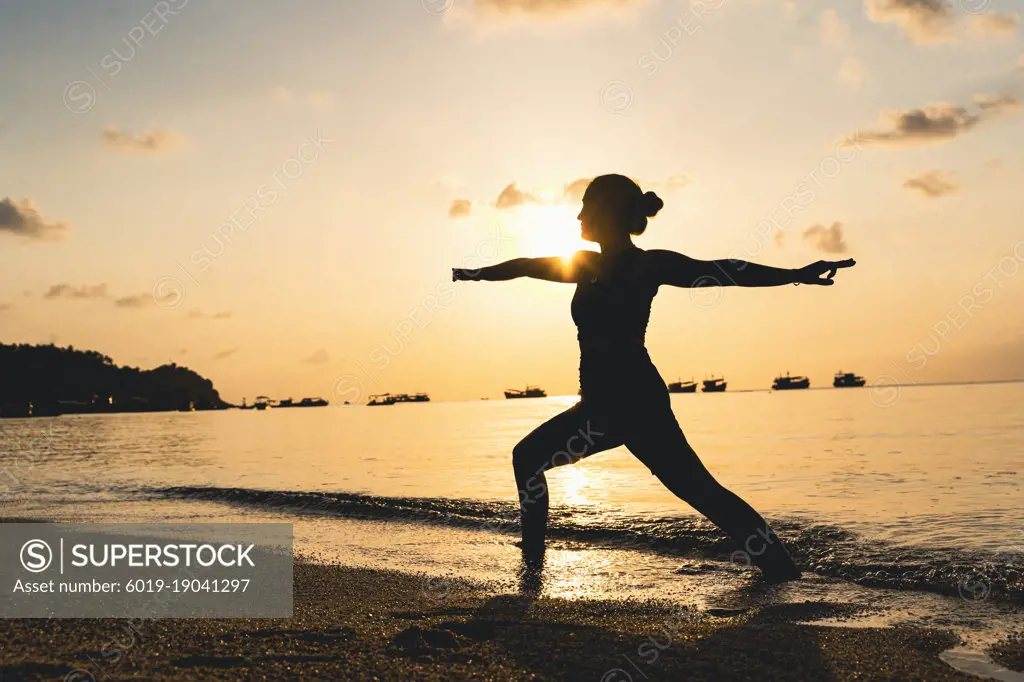 Woman doing yoga at the beach.