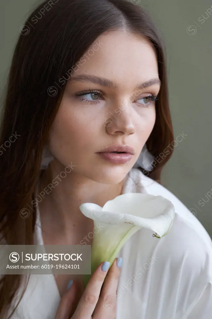 Pretty model girl in dress on green  background with feces flower