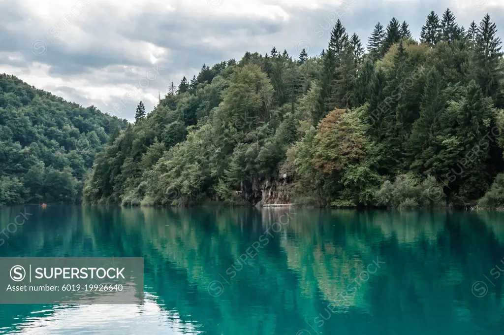 Lonely boat in the Plitvice Lakes of Croatia in cloudy day.