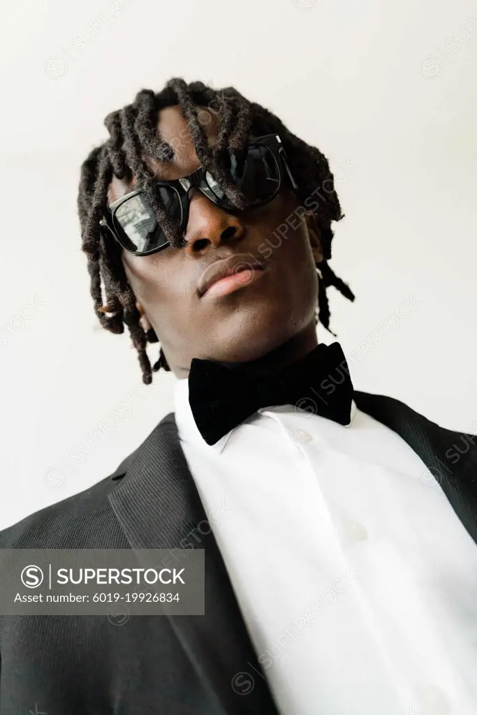 Portrait of the black man with dreadlocks wearing a suit with su