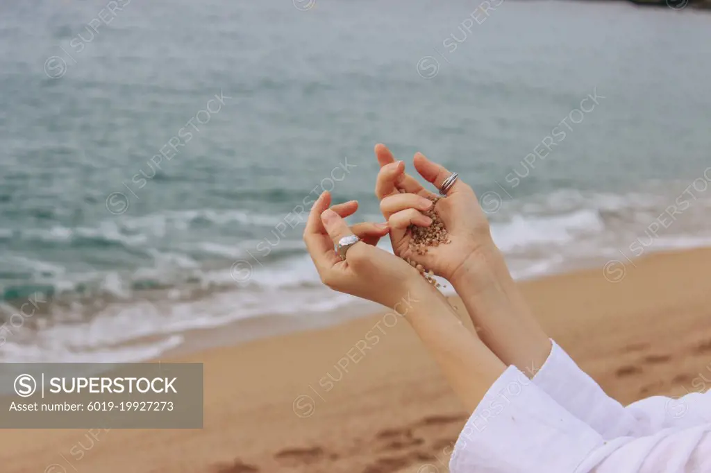 Girl hands on the background of beach and sea