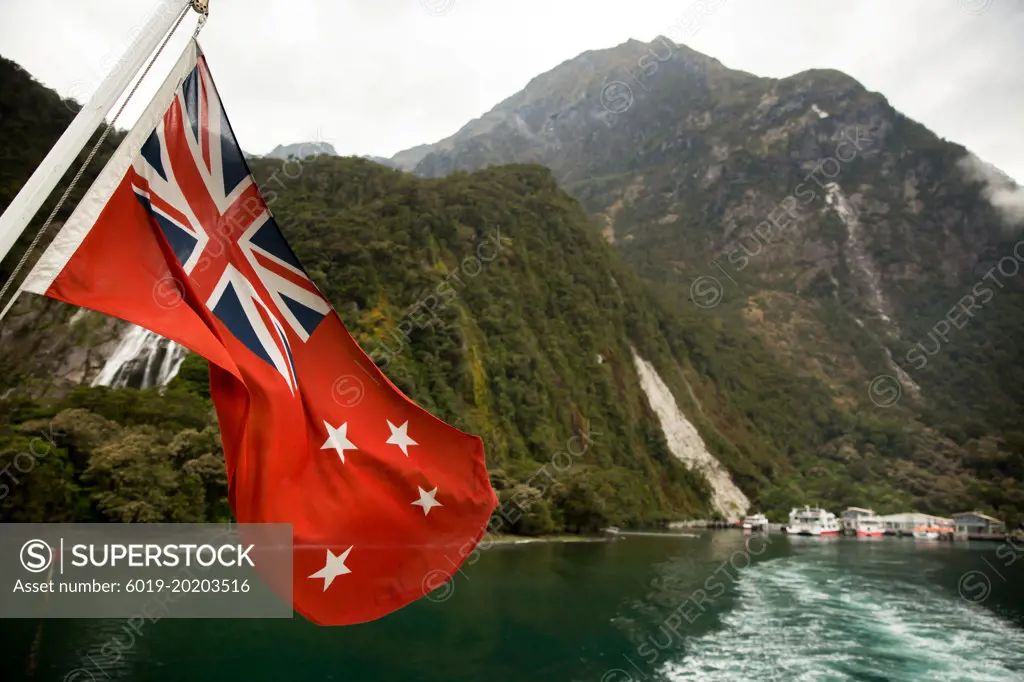 New Zealand Flag waving in Milford Sound in New Zealand