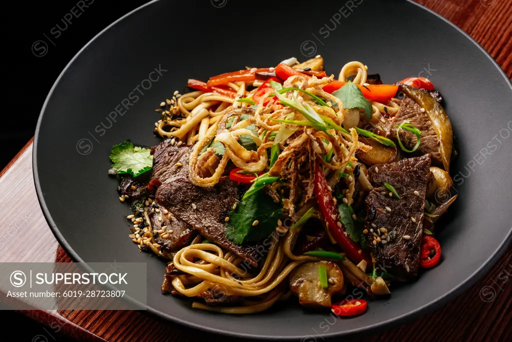 asian noodles with beef and vegetables. restaurant menu