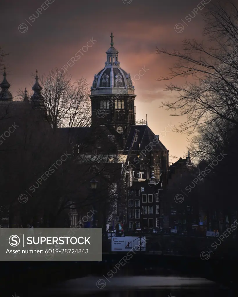 amsterdam canal at sunrise with bridge and boats