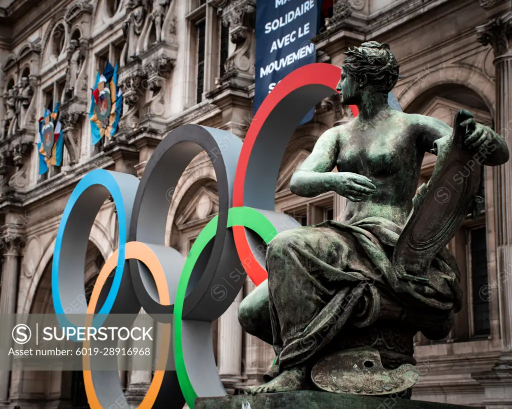 woman statue in front of paris city hall with olympic rings