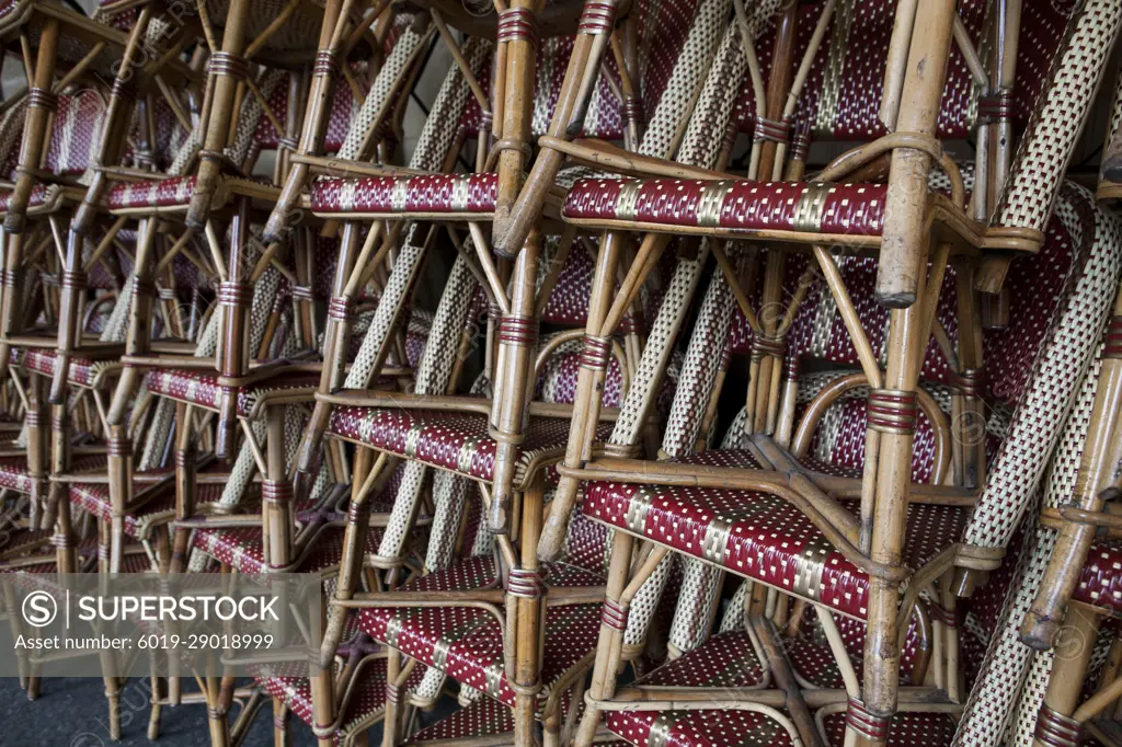 Cafe chairs stacked on a sidewalk in Paris, France.