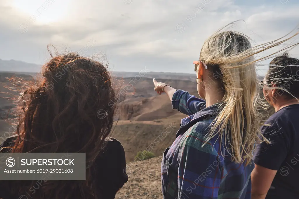 Three people looking to the Grand Canyon from a viewpoint, windy