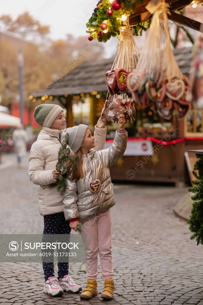 Two girls walk at the Christmas market in Germany, gingerbread