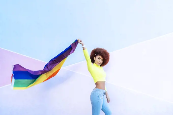 woman with afro hair displaying the lgtbi flag