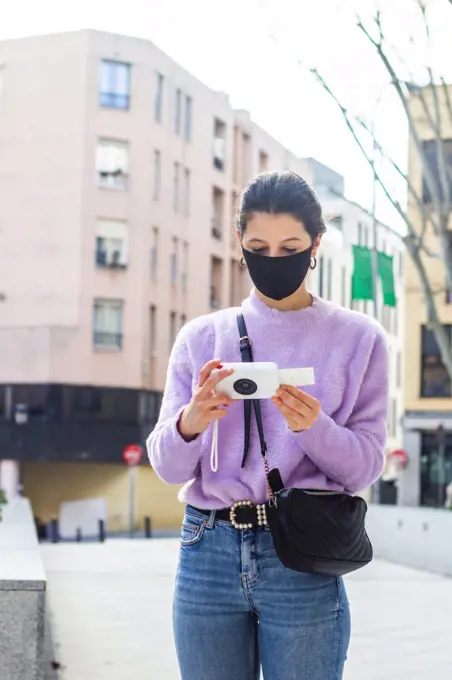 young woman with camera printer on the street