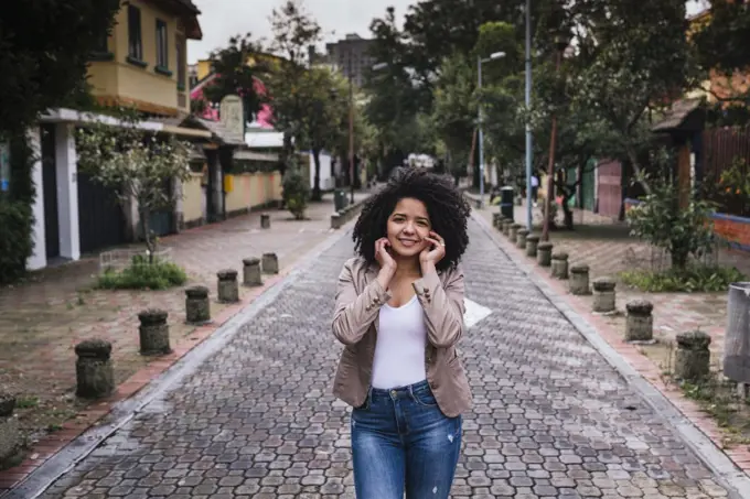 Portrait of cute girl with curly hair on the street