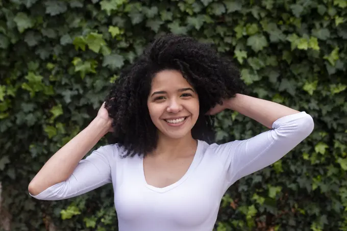 Portrait of cute girl with curly hair on the street