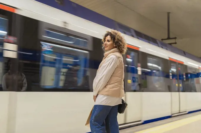 young woman waiting for the subway after shopping