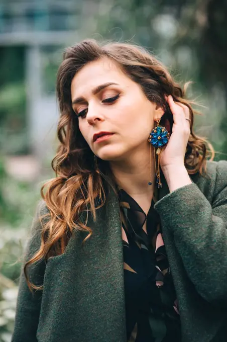 girl in a green coat with beautiful earrings