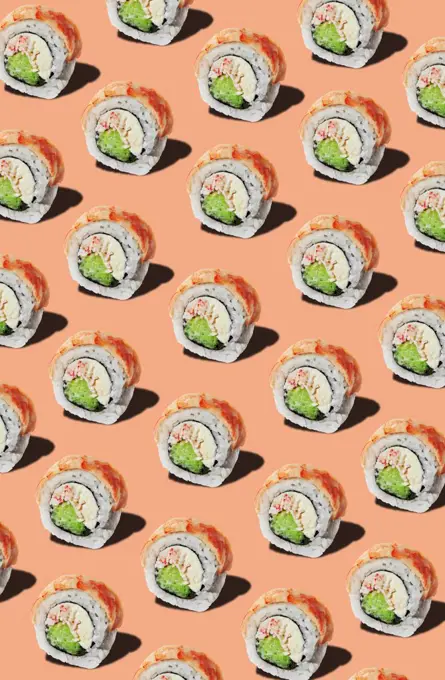 Pattern of rolls with prawn fillet on pinkish orange background